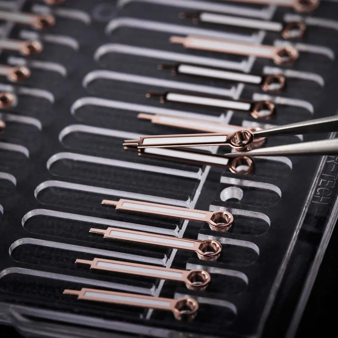 Multiple cuticle nippers with rose gold handles placed in a black tray.