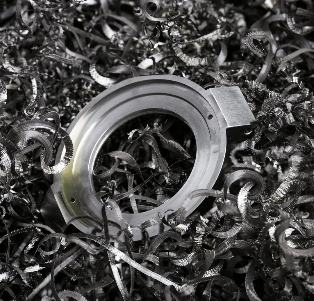 Close-up of a metal machinery part surrounded by metal shavings.