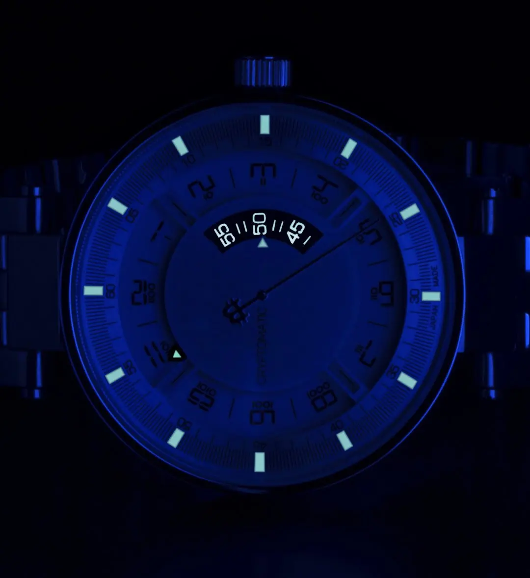 A close-up of a bitcoin wristwatch with a glowing blue and white face in a dark setting.